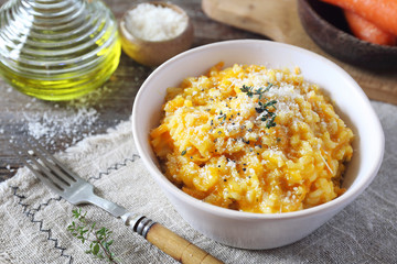 Italian cuisine. Bowl of carrot risotto, olive oil and grated parmesan cheese