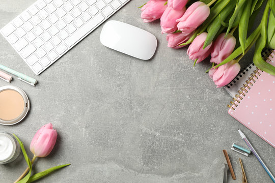 Composition with pink tulips on grey background, space for text