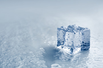 Crystal clear ice cube on grey background, closeup. Space for text