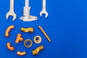 Set of tools and spare parts for plumbing on blue background with space for advertising