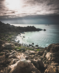 Fototapeta na wymiar paisaje de rocas en borde costero al atardecer nublado