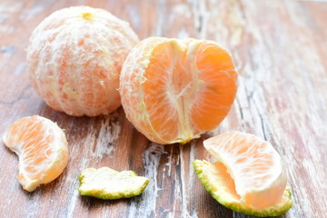  Natural, whole, chopped tangerines on wooden background