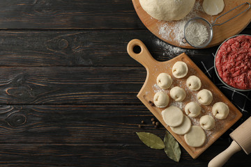 Composition with minced meat and dumplings on wooden background, top view