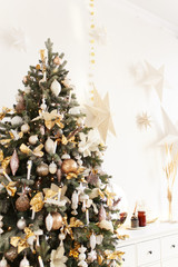 Concept of Christmas decoration for the house, horse on the background of a Christmas tree, bokeh, garlands, white chest of drawers, children's room with toys and gifts, living room interior