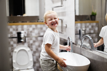 fun kid wash hands in real interior bathroom