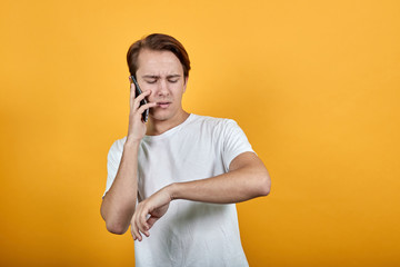 Business man financial manager talking on the phone in the yellow background