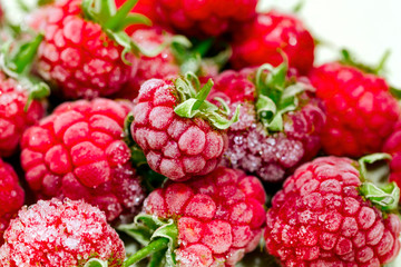 Close-up view on frozen raspberries on a branch, food background. Selective focus.