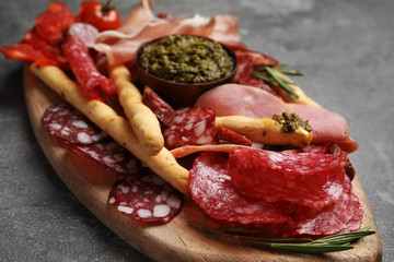 Tasty ham and other delicacies served on grey table, closeup