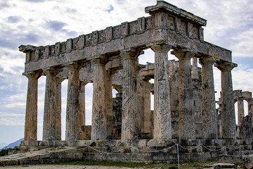 Obraz premium A part of the Temple of Aphaea located on the island of Aegina, with a cloudy sky at the background.