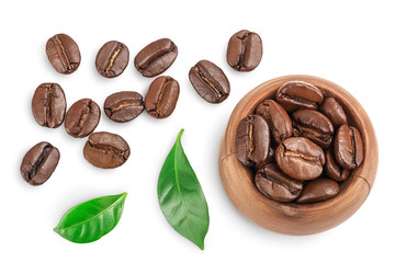 Heap of roasted coffee beans in wooden bowl with leaves isolated on white background with clipping path and full depth of field. Top view. Flat lay.