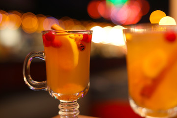 Tasty aromatic mulled wine on blurred background