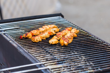Delicious bbq kebab grilling on open grill, outdoor kitchen. Food festival in city. Tasty food roasting on skewers, food-court. Summer picnic