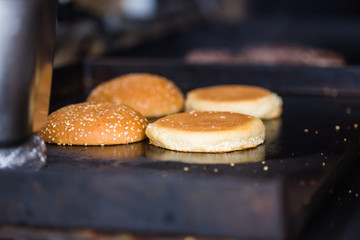 Fast food concept - Tasty buns with sesame on oven-tray.