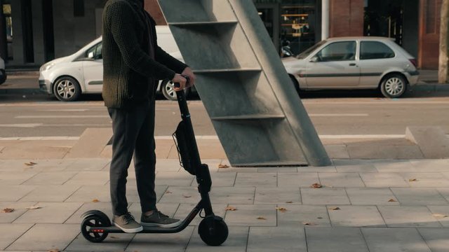 e-scooter rider, man ride sharing or rent personal eco transportation. man hipster riding an electric scooter road to work the modern way. Fast speed driving electric transport, day light