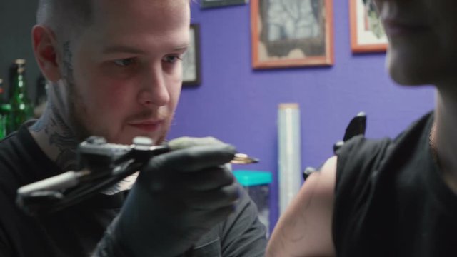 Video of young tattooer getting tattoo of snake in salon