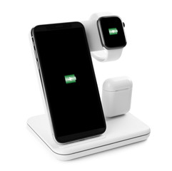 Set of gadgets charging with wireless pad isolated on white