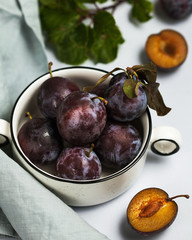 Ripe juicy plum on the plate as a whole and in context. Vegetarian food, ripe fruit. Food photo.