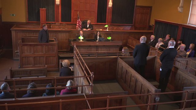4K: Court / Courtroom trial taking place. USA Flag.  Wide Shot. Tilt up
