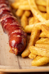 Fried sausage with french fries served on plate