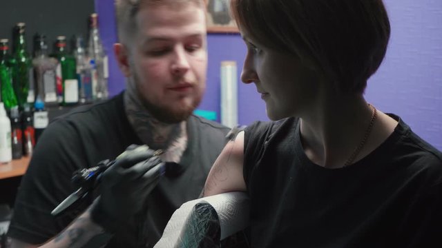 Video of young tattooer getting tattoo of snake in salon, process
