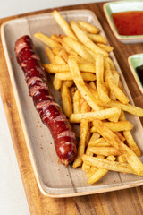 Fried sausage with french fries served on plate