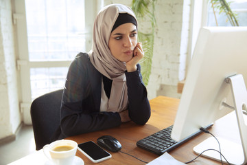 Attented working with computer. Portrait of a beautiful arabian businesswoman wearing hijab at...