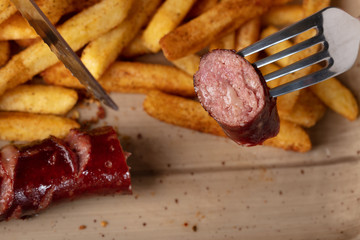 Fried sausage with french fries served on plate