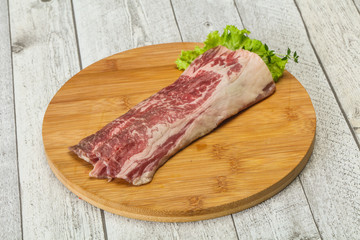 Raw beef bacon over wooden board