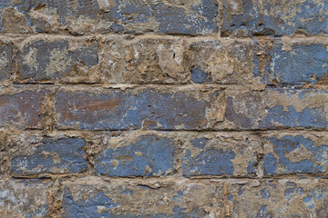 Old vintage shabby brick wall with peeling plaster. Grungy loft texture, background.