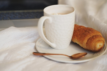 Breakfast in Flatley bed. Coffee mug and croissant are on the bed top view