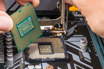 Computer processor maintenance detail. Hands installing a microprocessor chip. Replacement of...