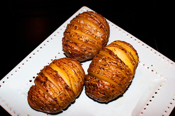 Potato specialty from Sweden. Hasselback potatoes grilled in the oven,