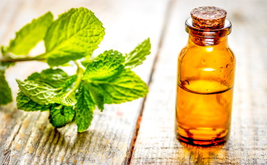 organic cosmetics with herbal extracts of mint on wooden background