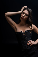 Naklejka premium Sexy woman in black corset looking at camera isolated on black