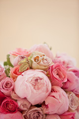 beautiful bouquet of peonies and other pink flowers with wedding rings for newlyweds