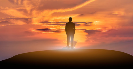 Success business people standing on the top mountain look into the future at sunrise.