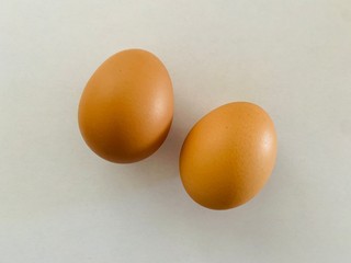 two brown eggs isolated on white background