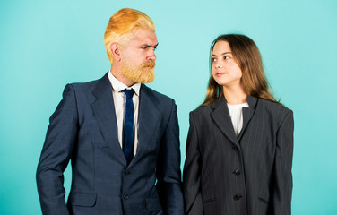 Bank concept. small girl in oversized jacket. choosing future career. family business startup. kid in business school. father and daughter in suit. modern office life. businessman dyed blond hair