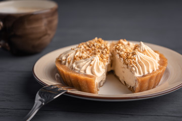 Dessert basket with salted caramel placed on a plate and cut, served with cappuccino.
