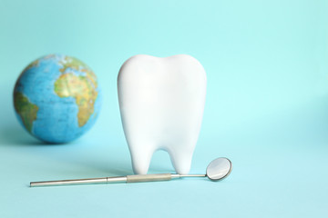 White tooth with dental instruments on a blue background in honor of the international day of the...