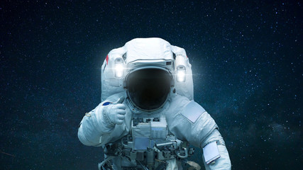 Spaceman in open space with hand shows like. Astronaut travels in space against the background of...