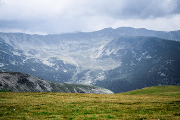 Fototapeta premium Landscape with mountains, green hills and cloudy sky, Transalpina road, Romania.