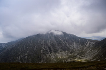 Landscape with mountains, green hills and cloudy sky, Transalpina road, Romania.