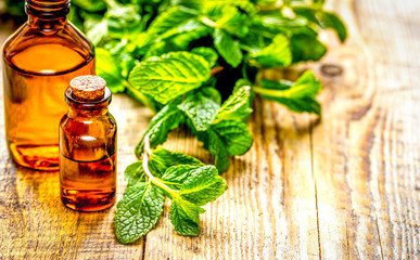 organic cosmetics with herbal extracts of mint on wooden background