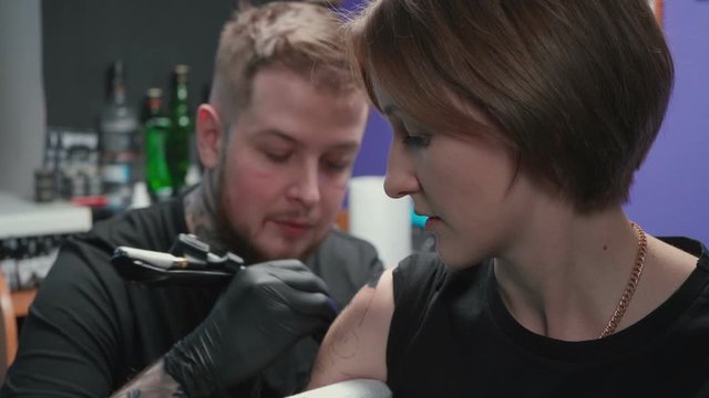 Video of doing dark tattoo of snake for woman in studio