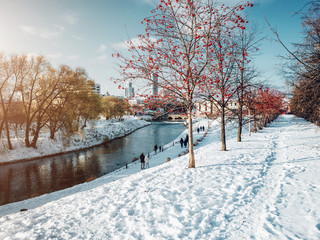 Naklejka premium Park in Yekaterinburg city along the Iset river at winter time at sunny day with people walking