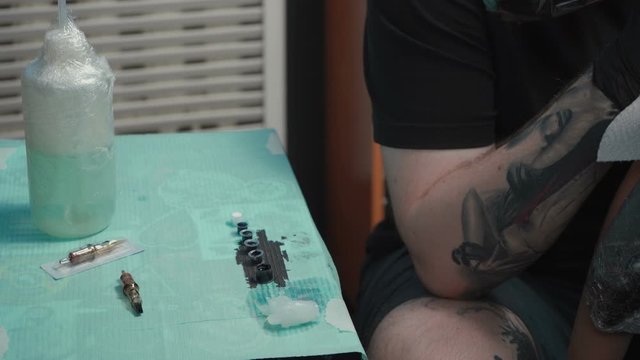 Video of man doing dark tattoo of snake in studio