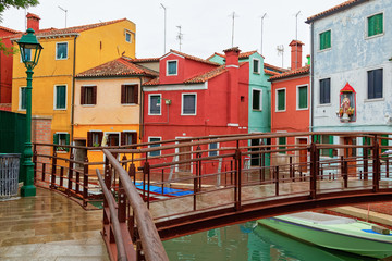 Venice landmark, Burano island canal, colorful houses church and boats, Italy.