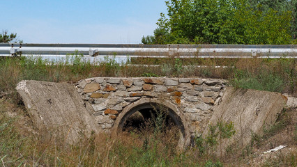 Reinforced concrete box culverts under the asphalt road. Box culvert is a structure that allows water to flow under a road, railroad, trail, or similar obstruction from one side to the other side.