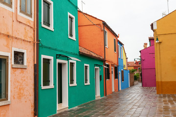 Venice landmark, Burano island canal, colorful houses church and boats, Italy.